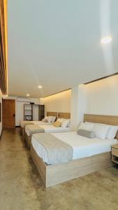 a row of four beds in a room at Cardedeu Residence Cangrejera in La Libertad