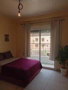 a bedroom with a bed and a large window at Dar LFarah Agadir & Rooftop in Agadir