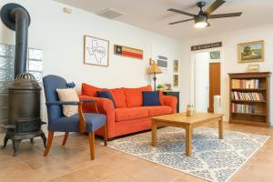 ein Wohnzimmer mit einem Orangensofa und einem Holzofen in der Unterkunft Charmingrusticcabinfarmpet Friendlyaffordable in Saint Jo