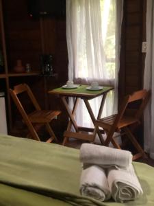 a room with a table and chairs and a bed at Refúgio eco Lodge in Nova Friburgo