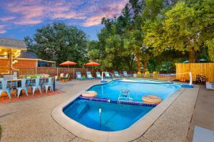 a large swimming pool with chairs and a table at Resort Style Backyard Pool Pickleball Court in Lake Dallas