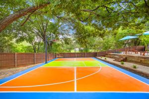 an orange and blue basketball court in a park at Resort Style Backyard Pool Pickleball Court in Lake Dallas