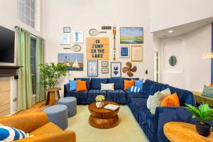 a living room with a blue couch and orange pillows at Resort Style Backyard Pool Pickleball Court in Lake Dallas