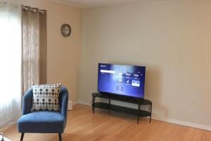a living room with a tv and a chair at Home beside WEM in Edmonton
