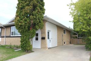 a house with a garage and a tree at Home beside WEM in Edmonton