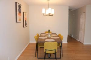 a dining room with a table and yellow chairs at Home beside WEM in Edmonton