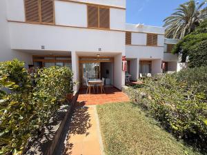 un edificio con un patio y una mesa delante de él en Las Brisas 38, 2 bedrooms and pool, en San Bartolomé