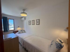 Un dormitorio con dos camas y un mostrador y una ventana. en Las Brisas 38, 2 bedrooms and pool, en San Bartolomé