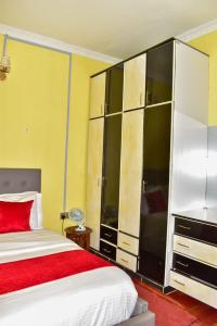 a bedroom with a bed and a large cabinet at Kukis Place in Embu Airstrip-2 bedrooms with more beds in Embu