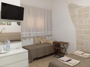 a bedroom with a bed and a table and a television at B&B Villa Sofia in Novoli