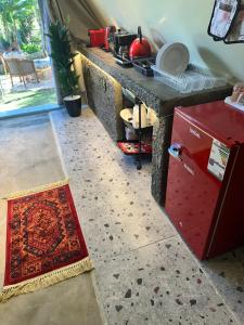 a kitchen with a counter and a red refrigerator at كوخ بلكونه in Taif