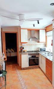 a kitchen with white cabinets and a stove top oven at PAUTANA, céntrico y a pocos minutos de Vigo in Cangas de Morrazo +23 photos