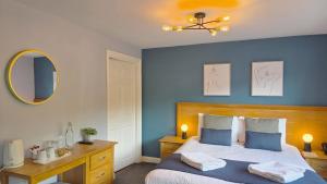 a bedroom with a bed and a desk and a mirror at Lakeview Manor in Dunkeswell