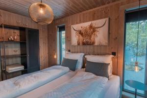a bedroom with two beds and a picture of a bull at Tiur, stylish new cabin with hot tub in Nystølen