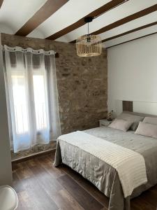 a bedroom with a large bed and two windows at Apartamentos Rurales El Rincón de la Sierra 