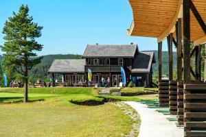 a large black building with people standing outside of it at Tiur, stylish new cabin with hot tub in Nystølen