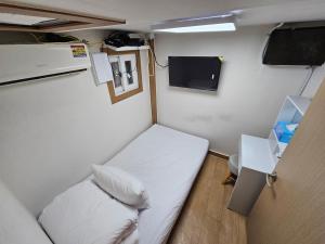 a small room with a bed and a tv at URBAN KS Stay in Seoul