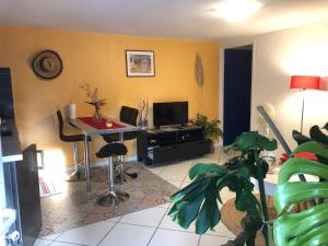 un soggiorno con un tavolo e una TV di Appartement Yucca entre Mer Montagne a Pérols