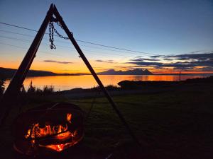a fire pit with a campfire in front of a lake at Blabergan Lodge in Nord-Lenangen