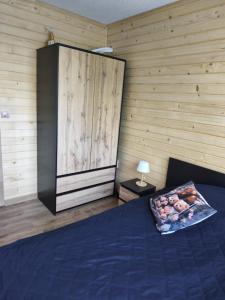 a bedroom with a blue bed and a wooden wall at Magiczna Chatka Nad Rzeką Bieszczady in Wietrzno