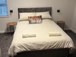 a bed with two pillows on it with two tables at 3 Bedroom House with free on site Parking next to the Canal in Keighley +2 photos