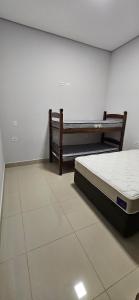 a room with two beds and a bench in it at 196 B · Loft B Hospede-se em Frente ao Parque ecológico in Indaiatuba