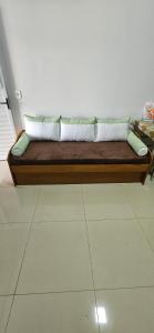 a wooden couch with pillows sitting on a floor at 196 B · Loft B Hospede-se em Frente ao Parque ecológico in Indaiatuba