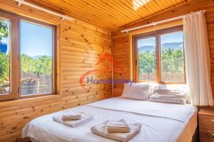 1 dormitorio con 1 cama en una habitación de madera con ventanas en Cirali Camping, en Kemer