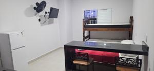 a room with a bunk bed next to a refrigerator at kitnet 7 Paulista Douglas · Loft 7 Espaço Inteiro Vista para o PQ Ecológico in Indaiatuba