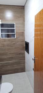 a bathroom with a toilet and a window and a door at kitnet 7 Paulista Douglas · Loft 7 Espaço Inteiro Vista para o PQ Ecológico in Indaiatuba