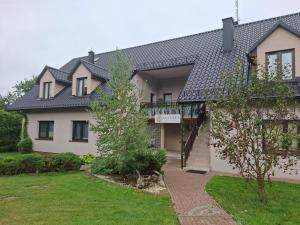 a white house with a black roof at Apartamenty TUTERRA IV in Zabagnie