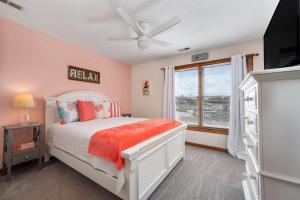 a bedroom with a white bed and a window at SDG2 Sea Glass Shack in Kitty Hawk +38 photos