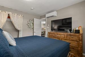 a bedroom with a blue bed and a flat screen tv at Downtown Cozy Home Base - Purple Sage 7 in Moab