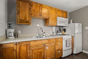 a kitchen with wooden cabinets and a white refrigerator at Downtown Cozy Home Base - Purple Sage 7 in Moab +17 photos
