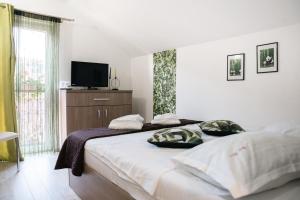 Un dormitorio con una cama grande y un televisor. en Casa BIM, en Zărneşti