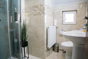 Un baño con lavabo, inodoro y ducha. en Casa BIM, en Zărneşti 21 fotos más