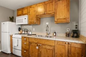 a kitchen with wooden cabinets and a white refrigerator at Downtown Cozy Home Base - Purple Sage 8 in Moab +17 photos