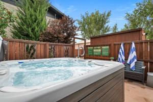 a large hot tub in a backyard with a fence at Downtown Cozy Home Base - Purple Sage 8 in Moab