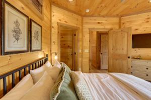 a bedroom with a bed in a log cabin at Family Oasis with Game Room and 2 Decks in Blue Ridge! in Ballew Mill