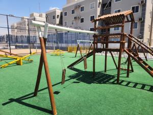 a swing set and a chair in a playground at Morada Aconchegante com 2 quartos and Sofá Cama in Imperatriz