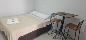 a small bed with a table and two chairs at kitnet 6 Paulista Douglas · Loft 6 Espaço Inteiro em Frente ao PQ Ecológico in Indaiatuba