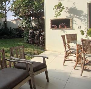 eine Terrasse mit Stühlen, einem Tisch und Stühlen in der Unterkunft Casa ampla com área de lazer, ar-condicionado, churrasqueira, pátio, 3 quartos in Torres