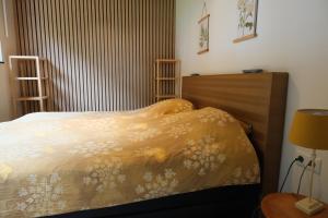 a bedroom with a bed with a yellow comforter at Boerderij de Windroos in Tollebeek