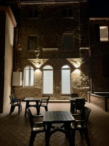 una stanza con tavoli e sedie di fronte a un edificio in mattoni di La Dimora Di Roberta a Montalcino