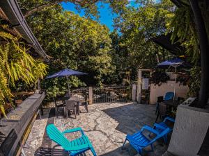 a patio with blue chairs and umbrellas at Hotel Casa de Hadas in Minca