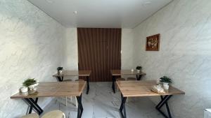 a restaurant with two tables and chairs and a wall at Meiman Hotel in Aktobe