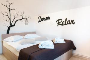 1 dormitorio con 1 cama con un árbol en la pared en Casa BIM, en Zărneşti