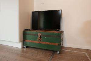 a green trunk with a flat screen tv on top at Boerderij de Windroos in Tollebeek