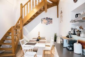 una cocina con mesa y sillas y una escalera en Casa BIM, en Zărneşti