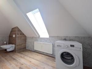 een wasruimte met een wasmachine en een toilet bij BohnApartments Schiller 7- Penthouse- WLAN- Parking- citynah in Erfurt